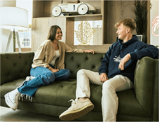 Dos jóvenes conversan en un sofá
